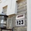 Numura zīme ēkai ar saules uzlādes baterijām un LED apgaismojumu